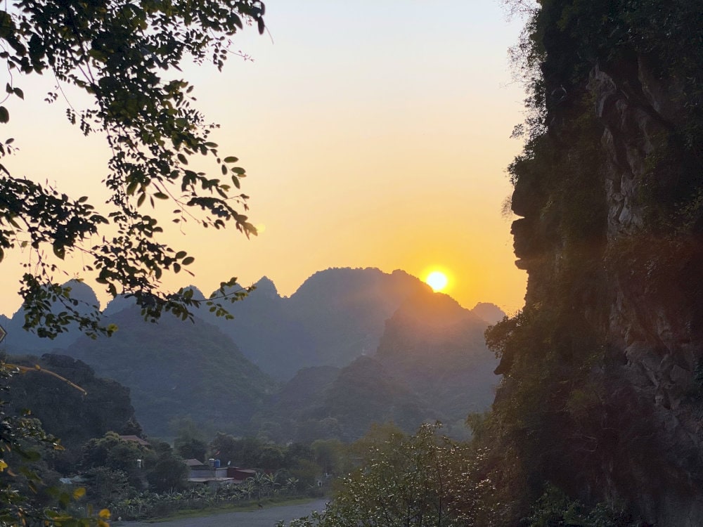 The sunset glows warmly from the mountaintop